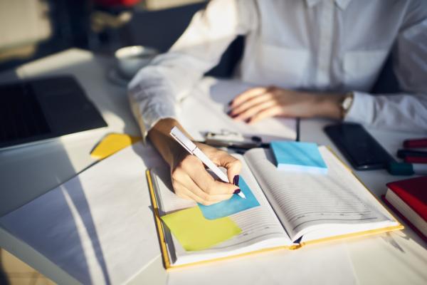 Persona estudiant i subrayant un llibre