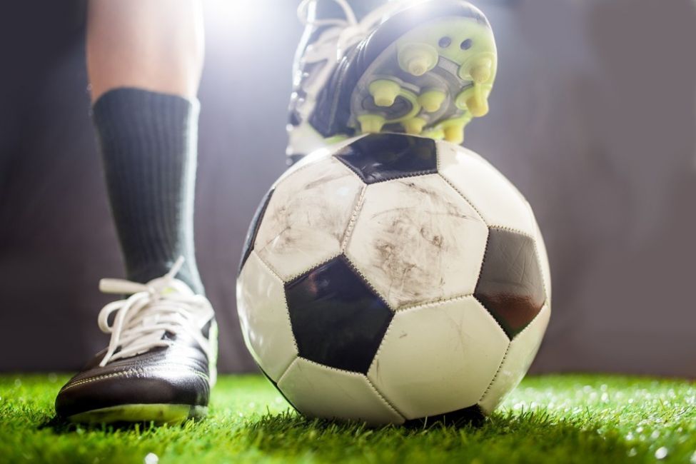 Peu trepitjan pilota de futbol de nit